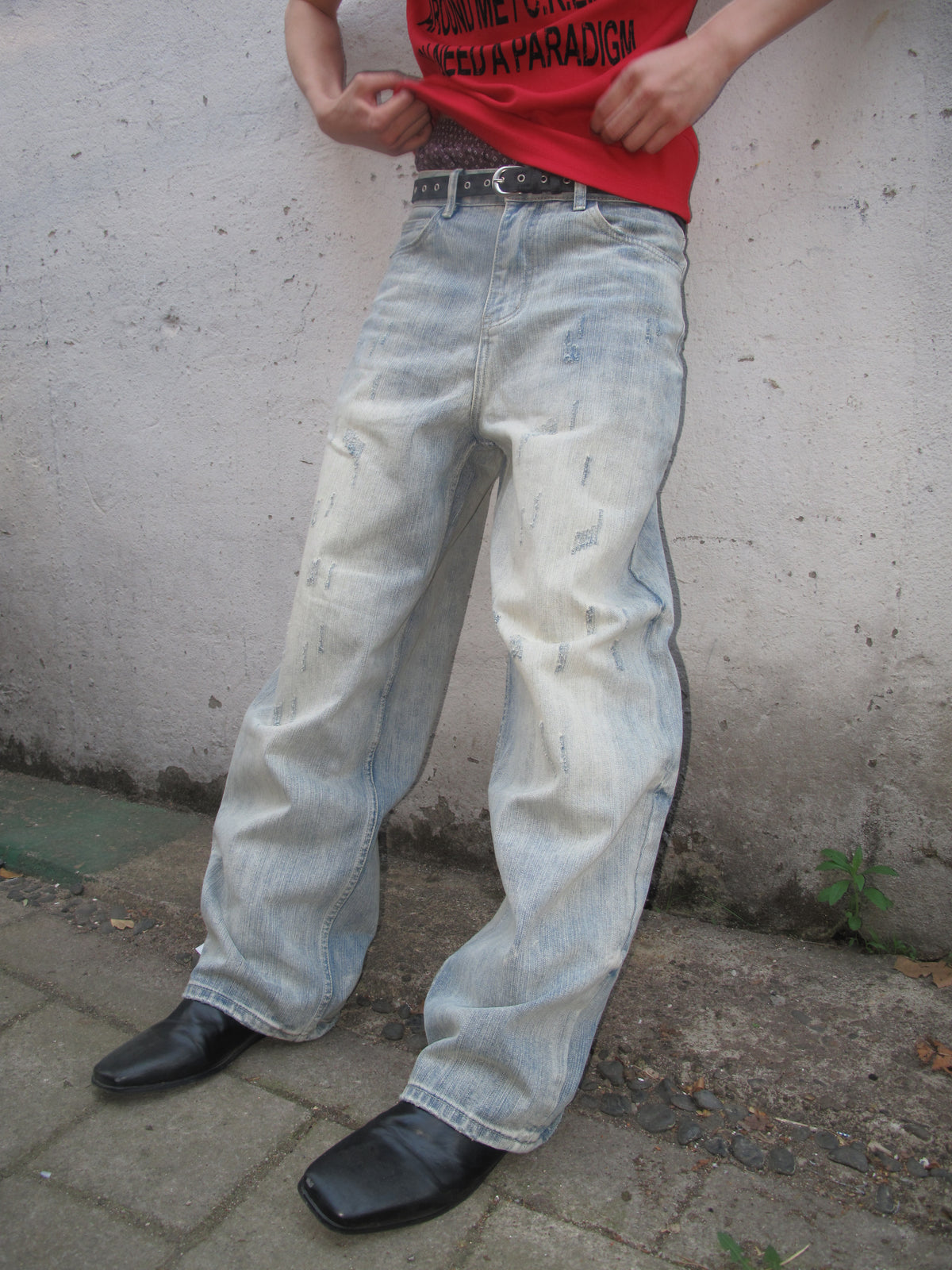 Close view of a red graphic T-shirt styled with washed wide-leg jeans