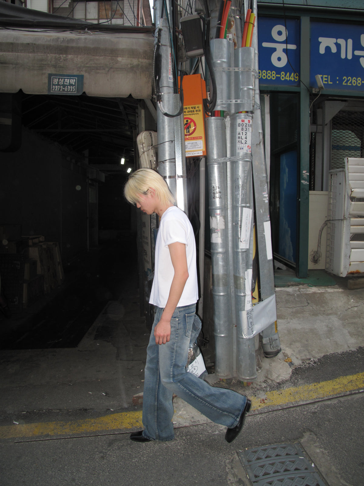 Blond model in a white T-shirt and jeans walking in Seoul