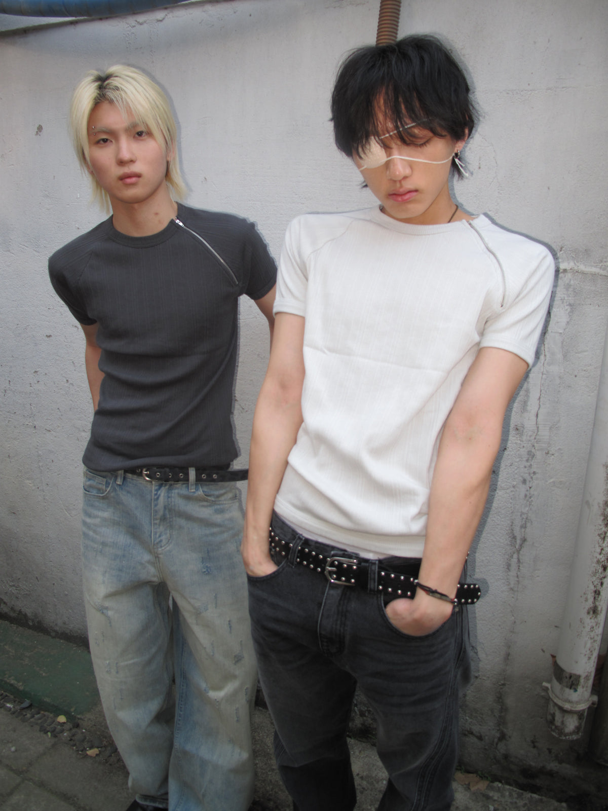 Two models in fitted black and white tops with denim
